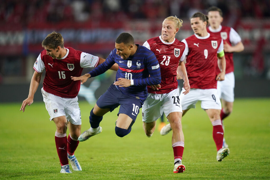 Kylian Mbappe, attaccante della Francia, nella morsa della difesa austriaca nel match di Nations League chiuso sull'1-1